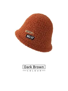 Detail shot of plush dark brown bucket hat showing soft fleece texture and MORE leather patch