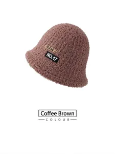 Close-up of coffee plush bucket hat featuring a metal MORE tag and NO.17 fabric patch