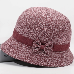 Detail of floral bucket hat with burgundy fabric, small white blossoms and silk ribbon bow