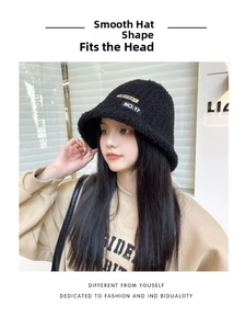 Close-up of black plush bucket hat with MORE and NO.17 fabric patches on female model