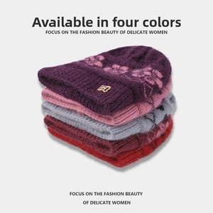 Close-up of winter knit beanies in four colors with floral pattern and fleece lining
