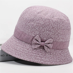Detailed macro view of purple floral bucket hat with delicate bow and cotton fabric texture