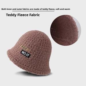 Detail of soft brown teddy fleece bucket hat with golden MORE tag and woven NO.17 patch