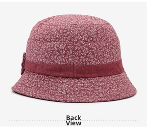 Détail d'un chapeau cloche floral rouge foncé pour seniors avec ruban et nœud décoratif