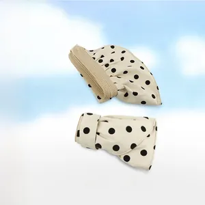 Detailed texture of polka dot foldable sun hat with wide brim in beige and black