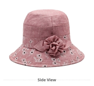 Detail of pink cotton sun hat with daisy print and elegant fabric flower decoration