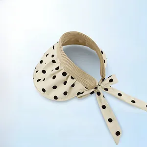 Close-up of a foldable sun visor with polka dot pattern and elegant bow detail