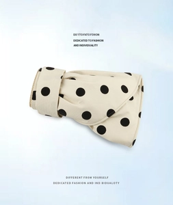 Detail of a beige polka dot sun hat showing the foldable fabric texture and brim edge