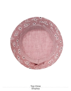 Top down view of a pink summer sun hat for elderly women with white daisy prints and a bow