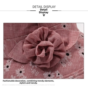 Detail of pink sun hat with white daisy prints and a 3D fabric flower decoration