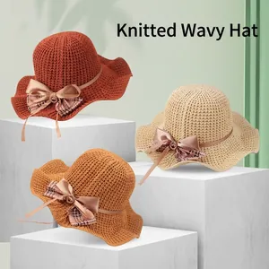 Knitted breathable sun hat with wavy brim and bow in brick red, khaki, and cream colors