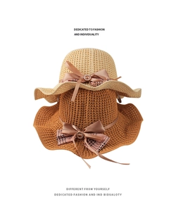 Detail of knitted sun hat featuring a satin bow with rhinestone buckle and houndstooth pattern