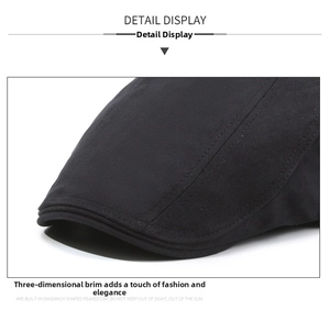 Close-up of black herringbone fabric and precise stitching on the vintage newsboy cap
