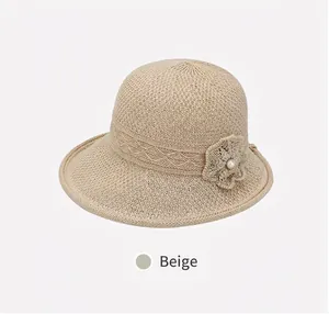 Detailaufnahme des beige gestrickten Sonnenhuts mit handgemachter Blume und Perle