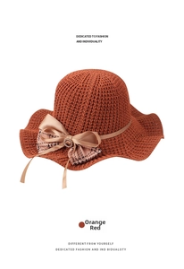 Detail of orange-red sun hat featuring multilayered bow with houndstooth and diamond buckle