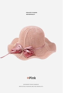Detailed view of the pink knitted sun hat showing wavy brim and rhinestone bow buckle
