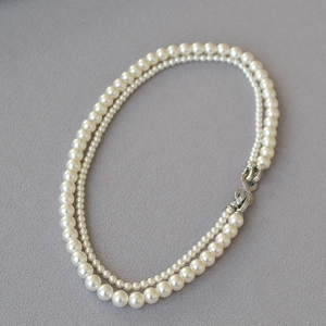 Dettaglio della collana di perle a doppio strato con fibbia a infinito brillante
