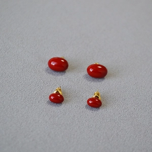 Detailed view of vintage burgundy enamel stud earrings in large and small sizes