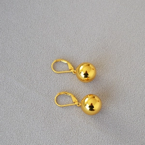 Minimalist gold hollow ball earrings with high polish finish and lever-back hooks