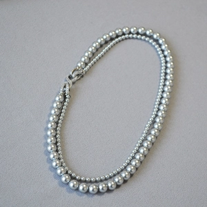 Collana a doppio filo di perle grigio argento con chiusura a nodo di zirconi luminosi