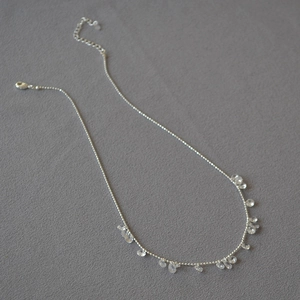 Detail of silver bead necklace with faceted crystal teardrop charms and lobster clasp