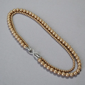 Dettaglio collana di perle champagne a doppio filo con chiusura a infinito
