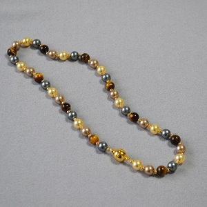 Detail of beaded necklace featuring tiger eye stones, pearls and metallic beads