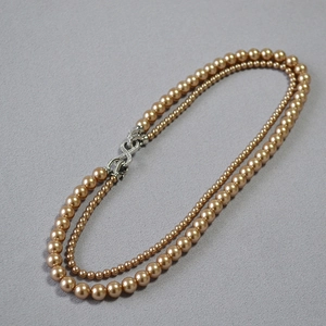 Dettaglio della chiusura a otto con zirconi su collana di perle a due strati