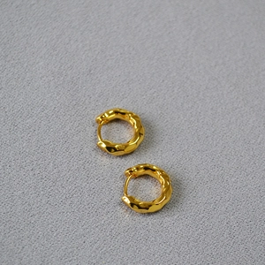 Close-up of gold-plated brass hoop earrings with elegant hammered water ripple texture