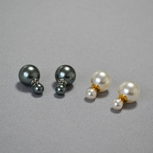 Close-up of double pearl earrings in grey and white with high luster and metallic finish