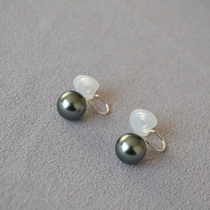 Détail de boucles d'oreilles clips perles gris foncé avec coussinet silicone