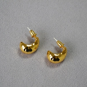Detailed view of gold hammered texture C-shape earrings with reflective metallic finish