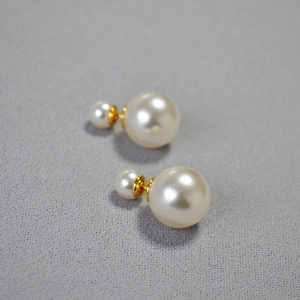 Macro detail of high-luster pearl earrings with elegant gold-plated metal backings
