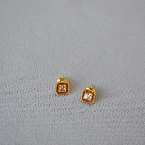 Détail de boucles d'oreilles carrées avec émail ambré et pierres de zircon cubique