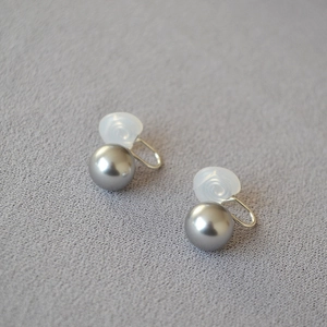 Détail de clips d'oreilles élégants en perles gris argenté avec coussinets en silicone doux