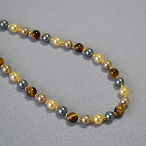 Macro detail of vintage beaded necklace with tiger eye stones and colorful pearls