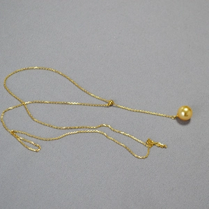 Vue détaillée du collier ajustable doré avec un pendentif en perle dorée rayonnante