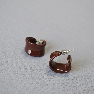 Macro shot of minimalist burgundy C-shape enamel earrings with 925 silver needles