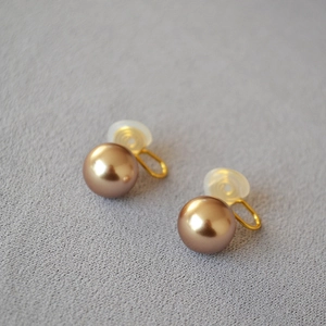 Vue détaillée des boucles d'oreilles clips perles champagne avec coussinets silicone