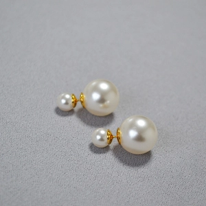 Elegant double pearl earrings with gold-plated 925 silver needles on grey fabric