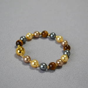 Detail of tiger eye and pearl beaded necklace with metallic beads and magnetic clasp