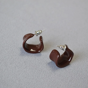 Glossy dark brown enamel C-shape hoop earrings with 925 silver needles on grey fabric
