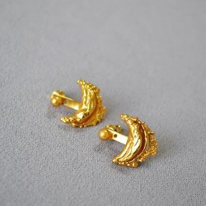 Macro detail of gold plated irregular moon ship earrings with artistic crinkle texture