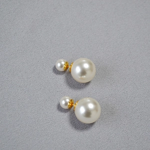 Detail of high-luster double pearl earrings with golden finish and 925 silver pins