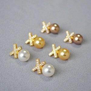 Macro shot of three-color pearl earrings with crisscross X-shaped diamond-set studs