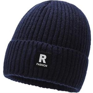 Detail of dark blue ribbed knit beanie with a stylish fashion logo patch on the fold