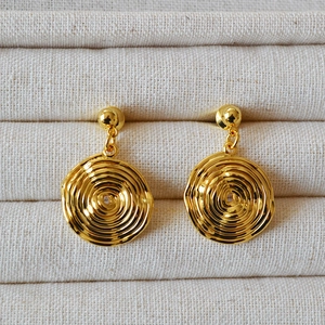 French vintage gold-plated brass disc stud earrings with spiral texture on fabric