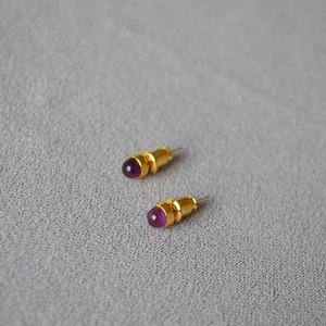 Detail-Makroansicht von runden Amethyst-Edelsteinen in minimalistischen Goldfassungen