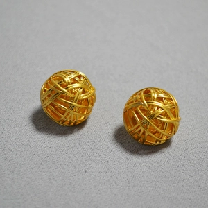 Macro shot of 925 silver needle hollow woven ball stud earrings in vintage gold