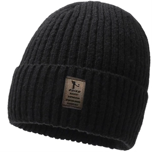 Close-up of the ribbed knit texture and brown leather label on the black winter beanie